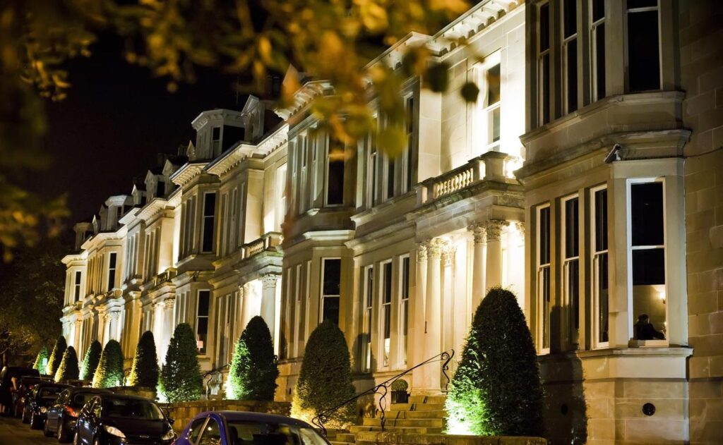 A completed property development by ARC Developments showing a row of sandstone period properties elegantly uplighted